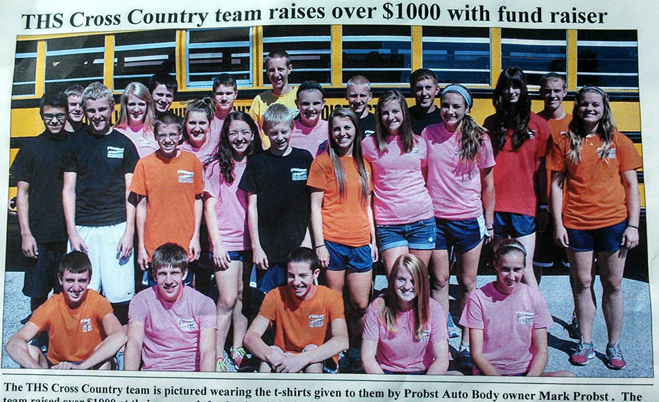 high school cross country team standing in front of a bus