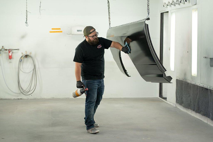 a technician painting a car