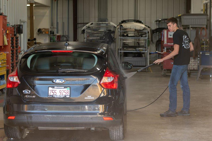 employees giving a truck a pre wash prior to body repairs