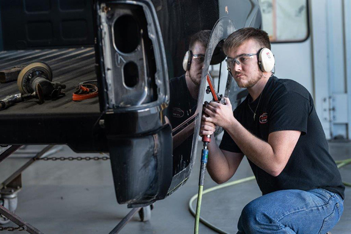 a repair technician making body repairs to a car